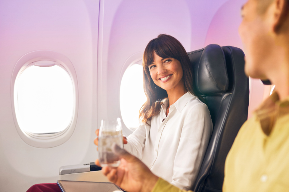 A couple clinking their glasses while seated on a VA flight