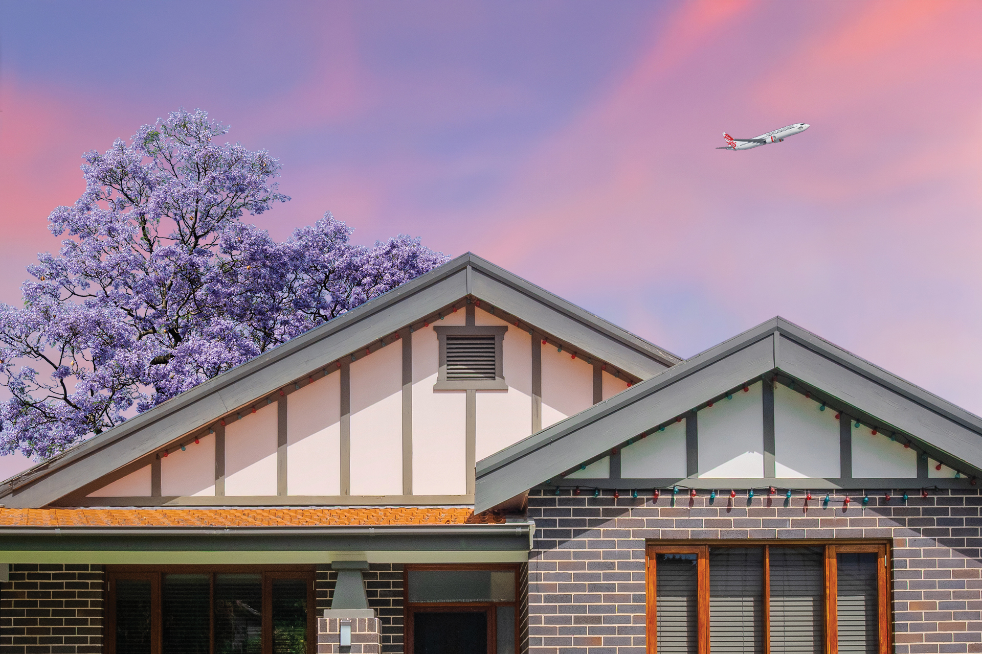 Plane flying over a house at sunset